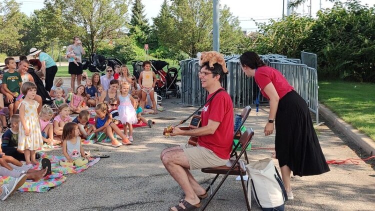 Herrick District Library librarians Rob Carpenter and Adrienne Baker perform during a Holland Farmers Market storytime.