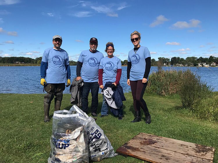 Volunteers clean up the Clinton River at Dodge Park in Waterford..