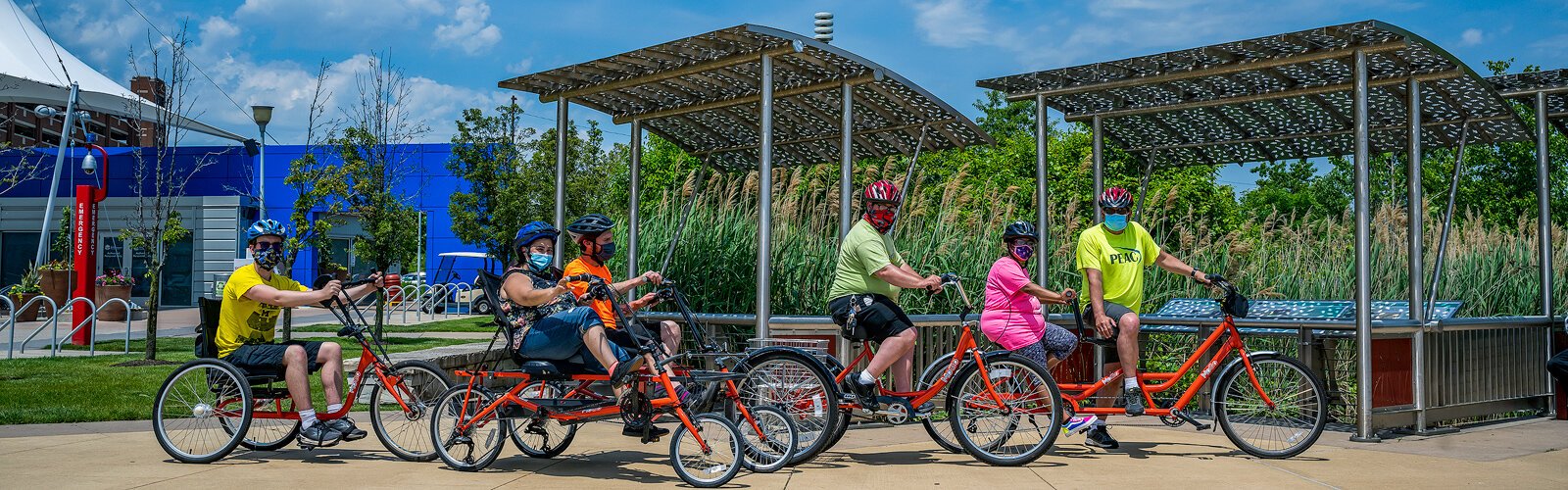 PEAC students Conor Waterman, Amanda Salinas, Owen Conley, Shawn Kohsmann, Tiara Sims, and PEAC founder John Waterman with MoGo adaptive cycles on the Detroit Riverwalk.