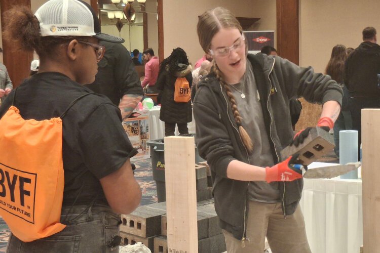 An attendee learns about brick laying at Build Like A Girl