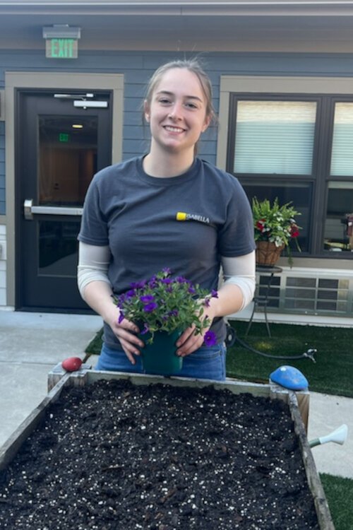 McKayla Rose from Isabella Bank volunteers to help plant flowers at the Memory Garden