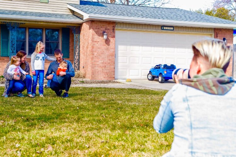 Families gather on their steps and front lawns for the informal portraits.