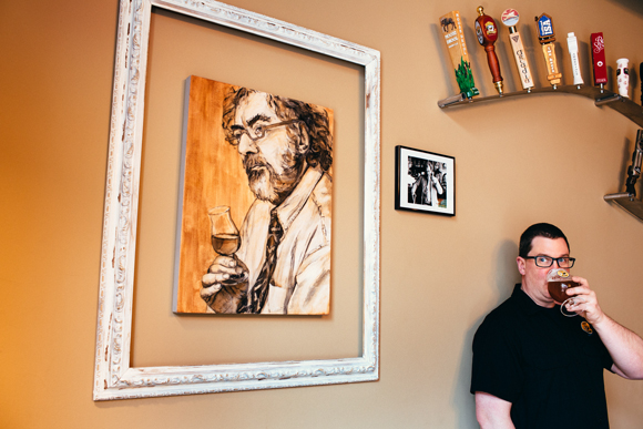 Jason Kasdorf, General Manager of 7 Monks stands next to a commissioned painting of Michael Jackson.  Michael Jackson is a famous writer  whose writing about beer literally changed what is in the glasses of beer drinkers around the world. 