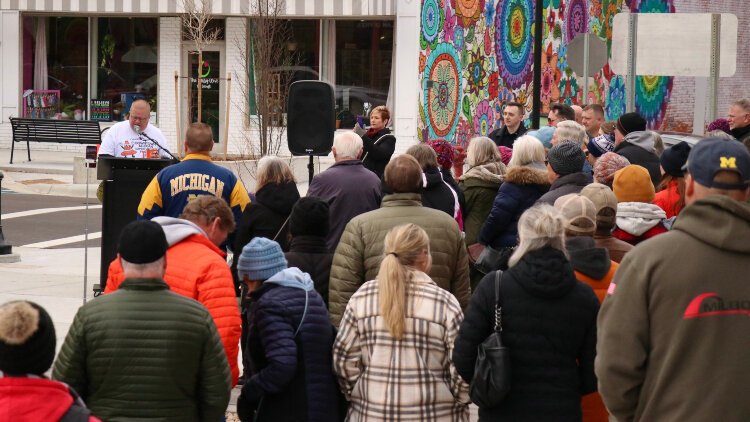 Allegan City Manager Joel Dye speaks to a large crowd during a ribbon cutting ceremony for the city's downtown streetscape project.