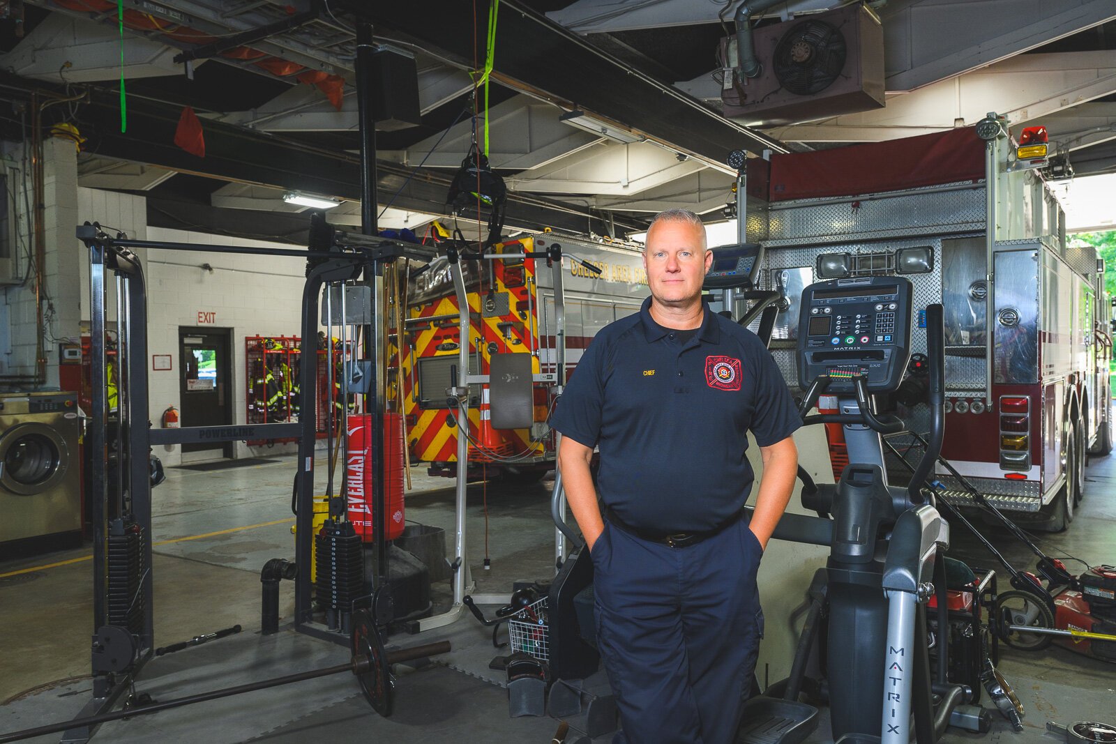 Chief Arbini in front of the workout area in the bay of the Chelsea fire station.