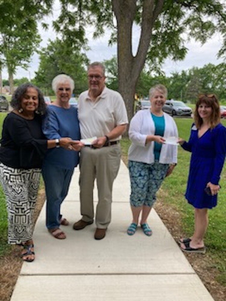 Gwen Tabb, Yvonne Cole, and Denise Porter present checks to Dick Porter, Albion Community Gardens, and Katie Gigliotti of Kids ‘N’ Stuff Children’s Museum.