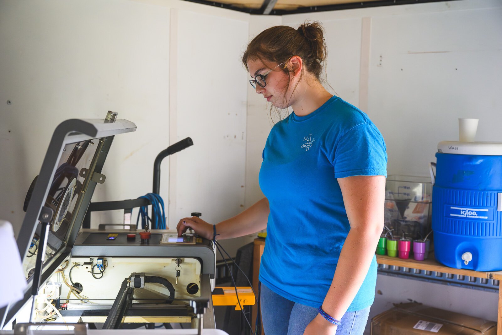 Annalies Walsh with a laser engraver in the Manchester Entrepreneurial STEM trailer.