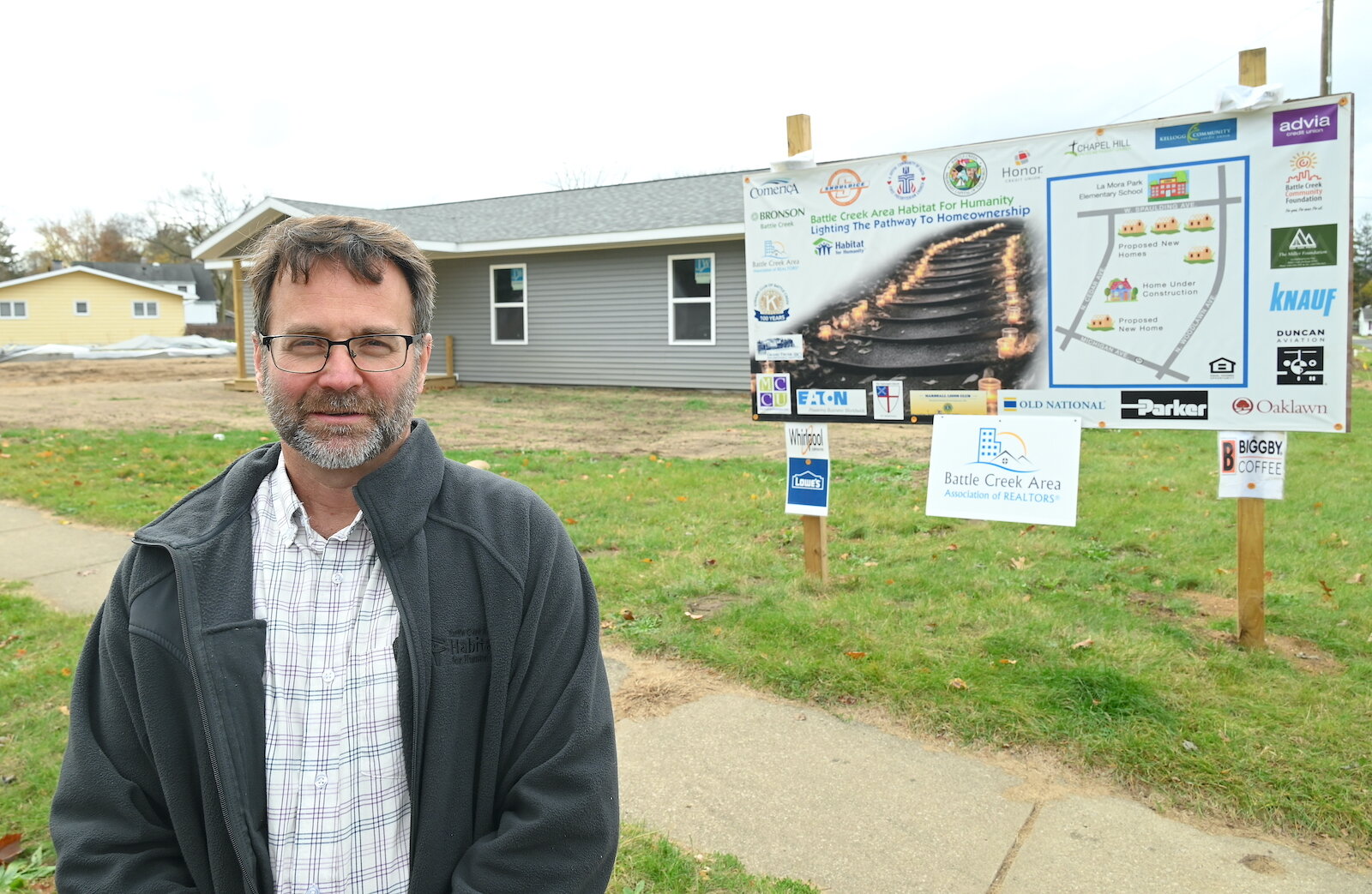 Mike King, executive director of the Battle Creek Area Habitat for Humanity, stands in front of a house being built on Woodlawn Avenue.