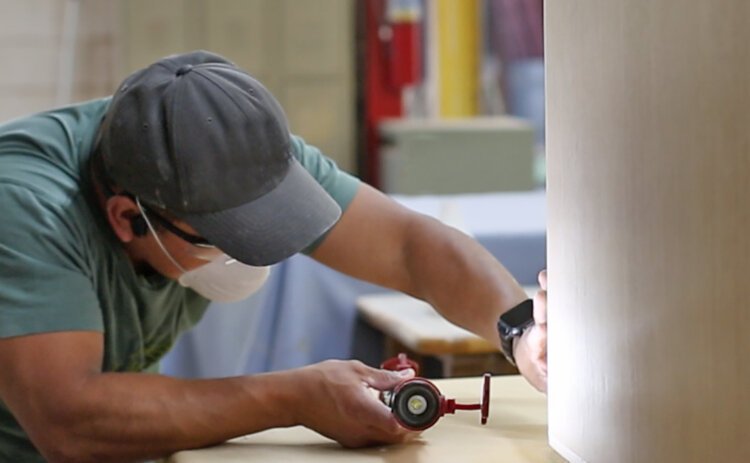 A worker creates furniture at The Worden Company.