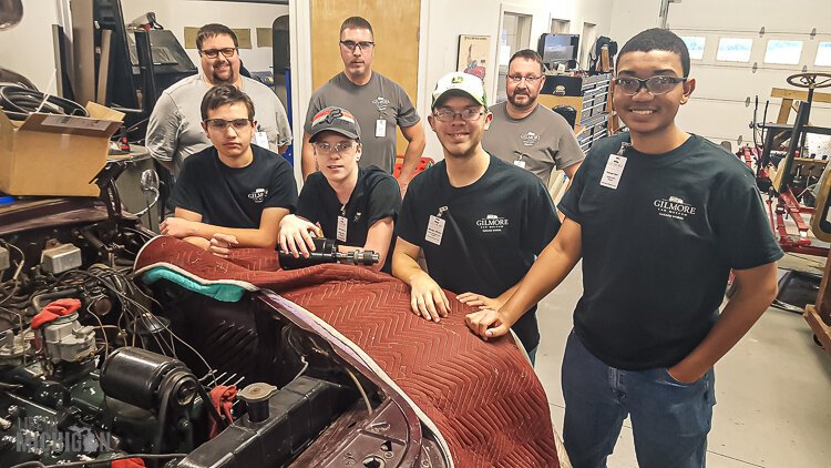 Garage Works alum pose next to the V 12 Lincoln at the Gilmore Car Museum.