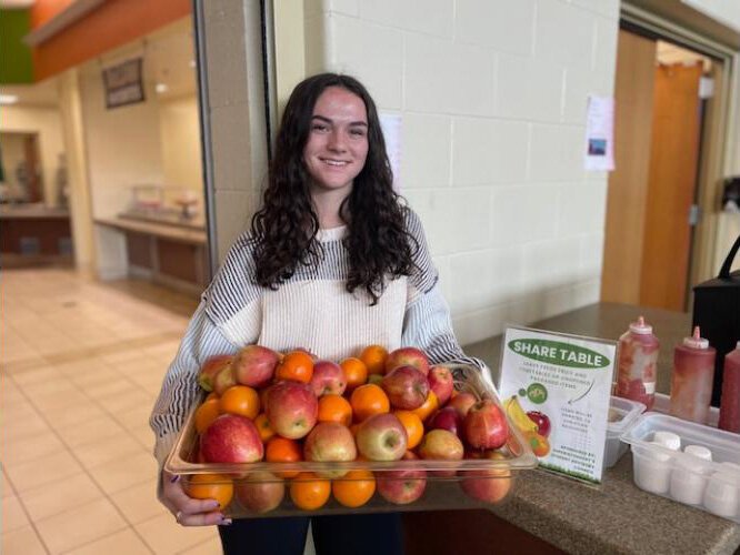 Lexi Gross shares some of the fresh fruit collected at Otsego High School.