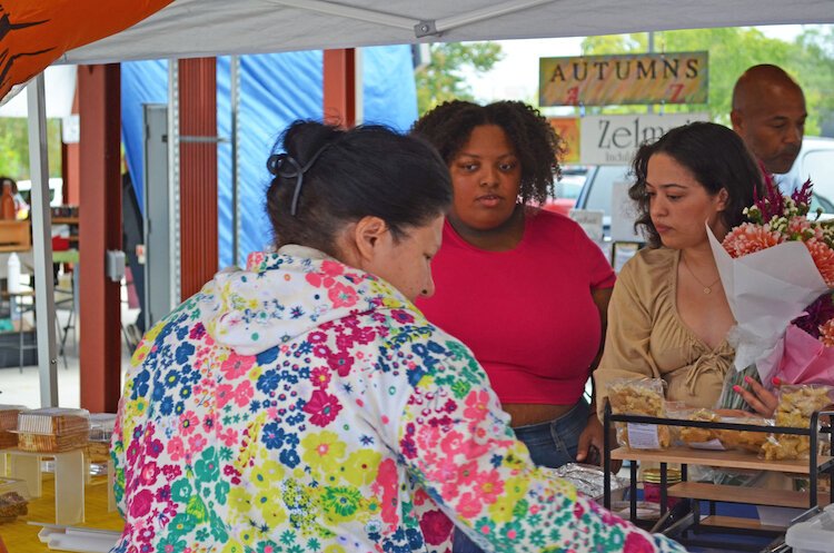 The couple works together to help customers at the Kalamazoo Farmers Market.