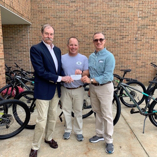 BIke Friendly Kalamazoo’s President Paul Selden, left, presents Portage West Middle School’s Physical Education Teacher James Righter and Assistant Principal Kevin Doerfler with BFK’s Bike-Booster Mini-Grant.