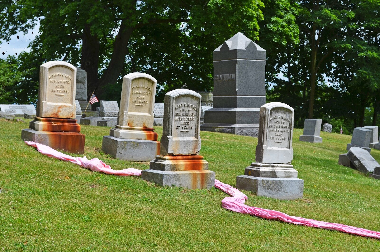 Photographs taken at Mountain Home Cemetery in Kalamazoo, using a long swath of donated white cloth dyed red and pink to connect the graves as a way of reflecting many faiths' belief that we are all truly interconnected and equal in death.