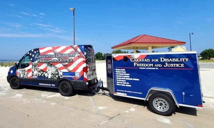 Picture shows a van and trailer decorated with the message "Caravan for Disability Freedom and Justice 2024."