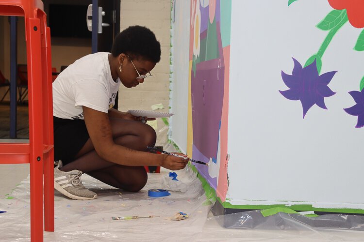 Anaïs Adjahi works on her mural.