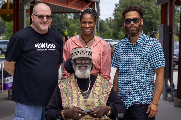 Yeshwua Israel (center) poses with his family members and DNSWM Program Manager Hank Bostic.