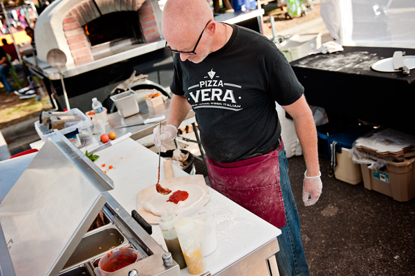 Using fresh ingredients, Pizza Vera’s Terry Baker makes a pizza at the Kalamazoo Farmers Market. 