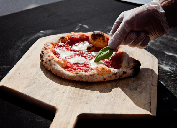 Terry Baker adds fresh Basil leaves to one of his pizzas. 