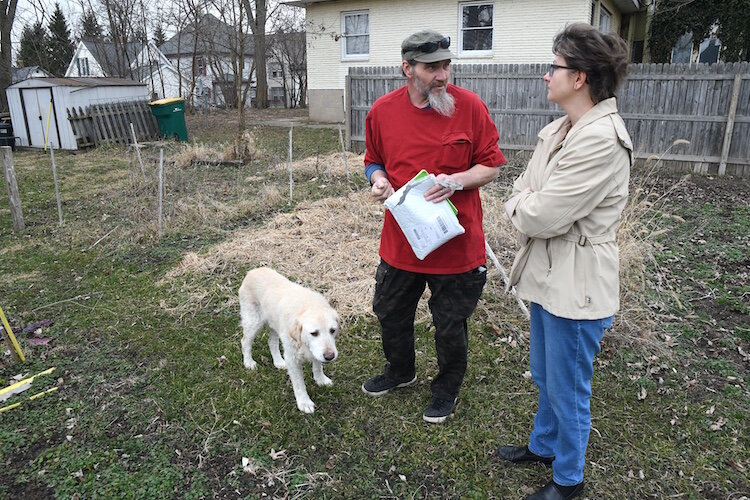 Thomas Hart, main caretaker of the Fremont Garden, and Jackie MacCannell, volunteer, discuss plans for this year’s garden. Also seen in the photo is Jake, the garden’s mascot.