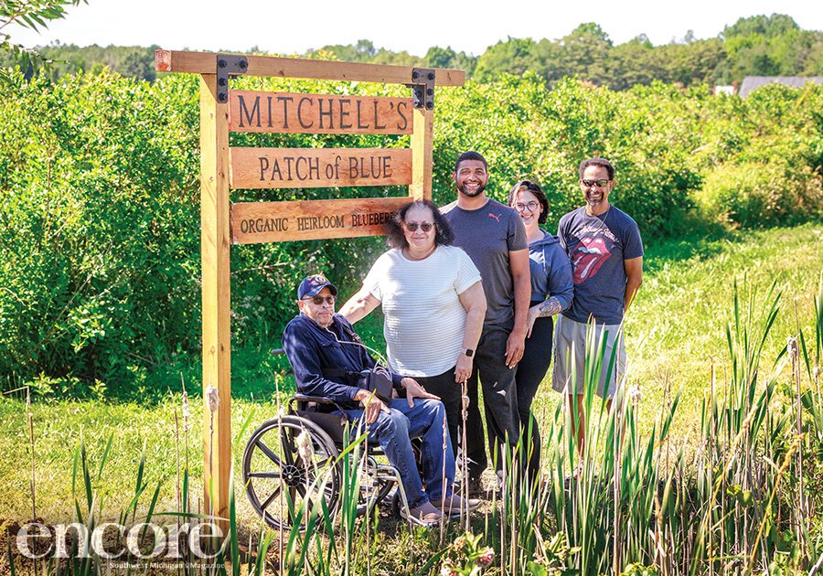 The Mitchell family, from left, Larry and Ginny Mitchell, Kyle and Natalie Mitchell, and Craig Mitchell, in front of the sign for their farm.