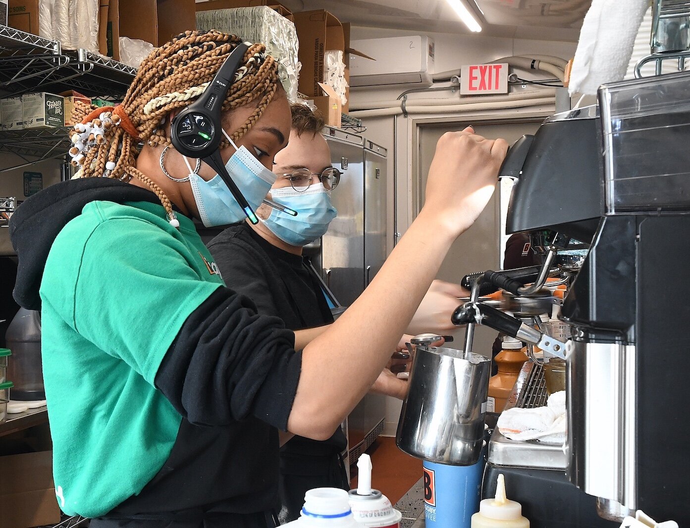 Courtney Jacobs, left, and Thomas Baker prepare coffee at the newly open drive-up Biggby Coffee shop in Urbandale.