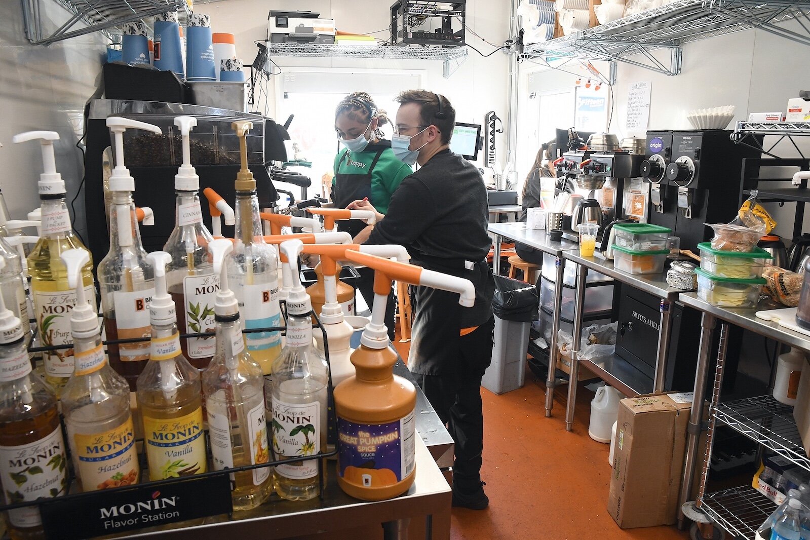 Thomas Baker, left, and Courtney Jacobs prepare coffee at the newly open drive-up Biggby Coffee shop in Urbandale.