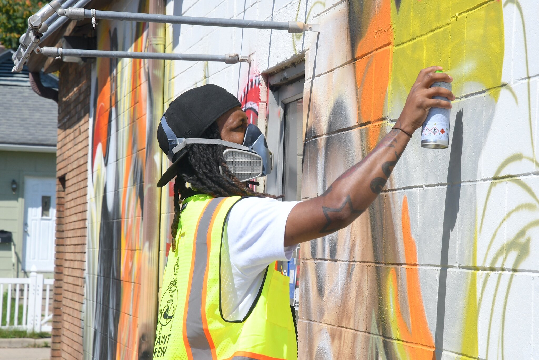 Jaziel Pugh of Battle Creek works on his mural on a wall of the Calhoun Laundry.