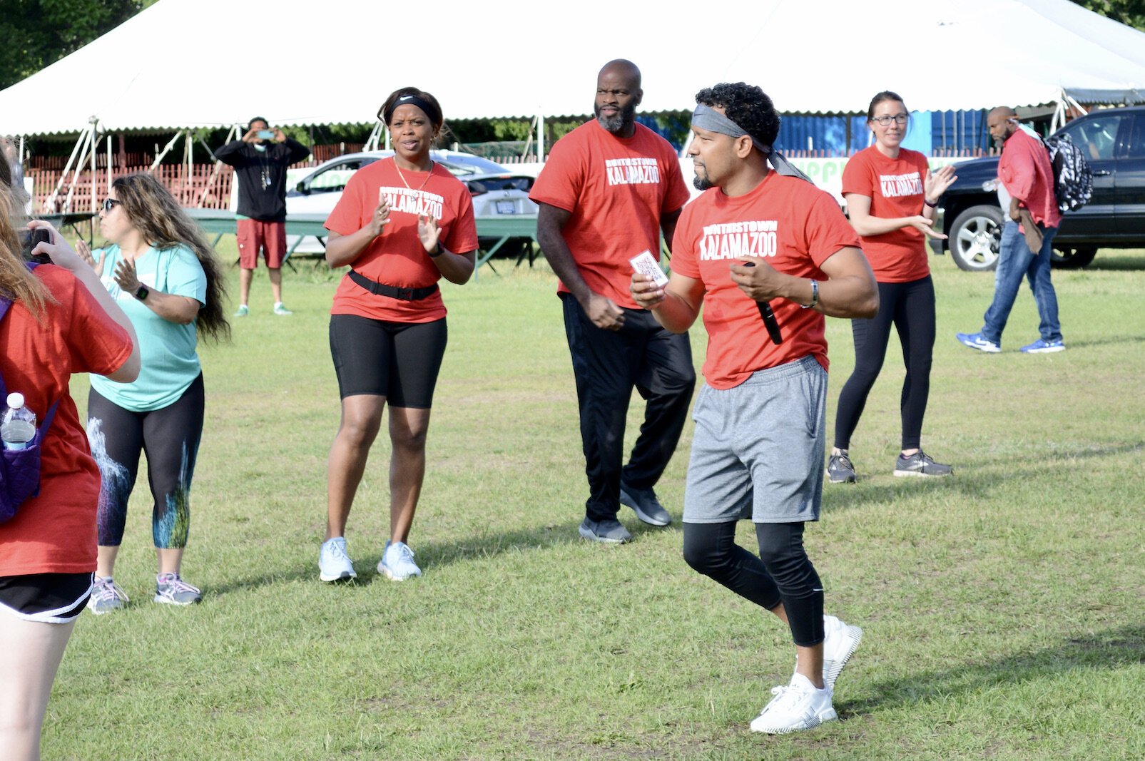 : Eric Cunningham (foreground, red shirt), leading a Run This Town warm-up.