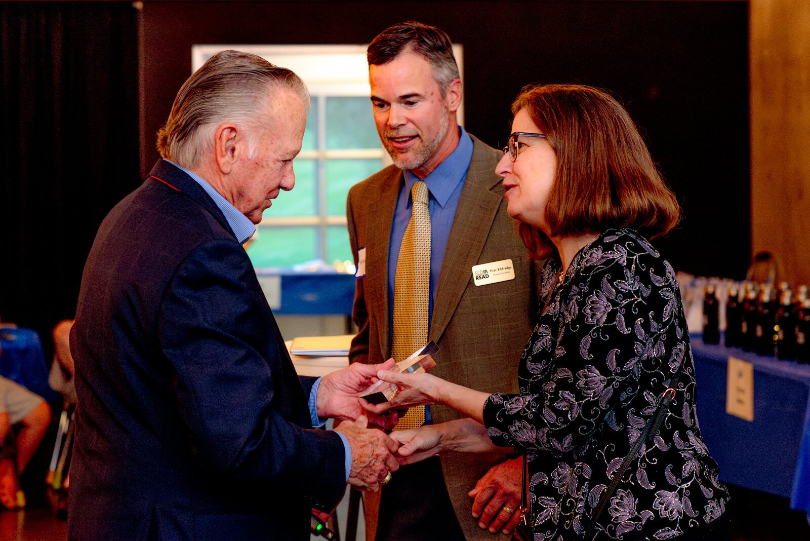 Board Members Hilary Arthur and Pete Eldridge congratulate González.