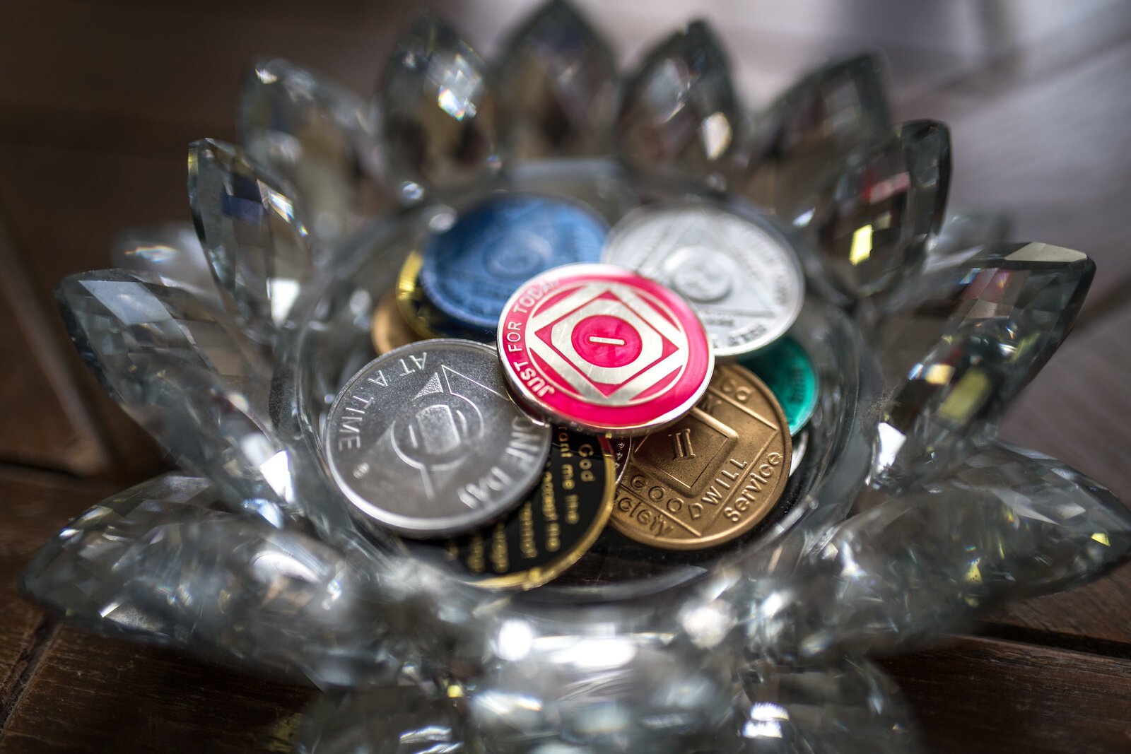 The coffee table has a dish full of sobriety coins.  David Harris is three years and eight months sober.