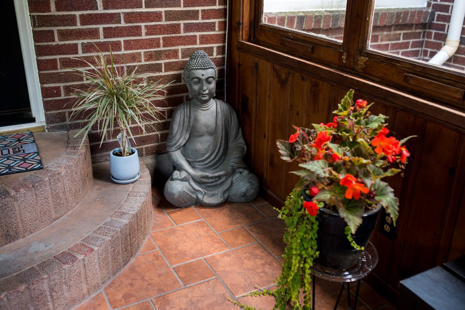 A stone Buddha sits peacefully in a corner of his mediation room.