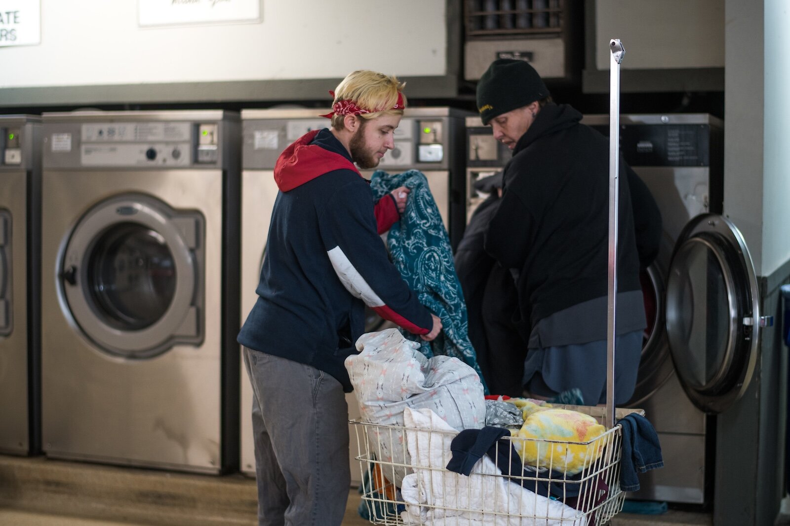 A volunteer helps "Lorrol Tyler" with a load.  Lorrol Tyler used to be a restaurant manager, before the pandemic. She says she's seen fungus growing in tents, because of rain and condensation. She's also seen how "the kindness of others is awesome."