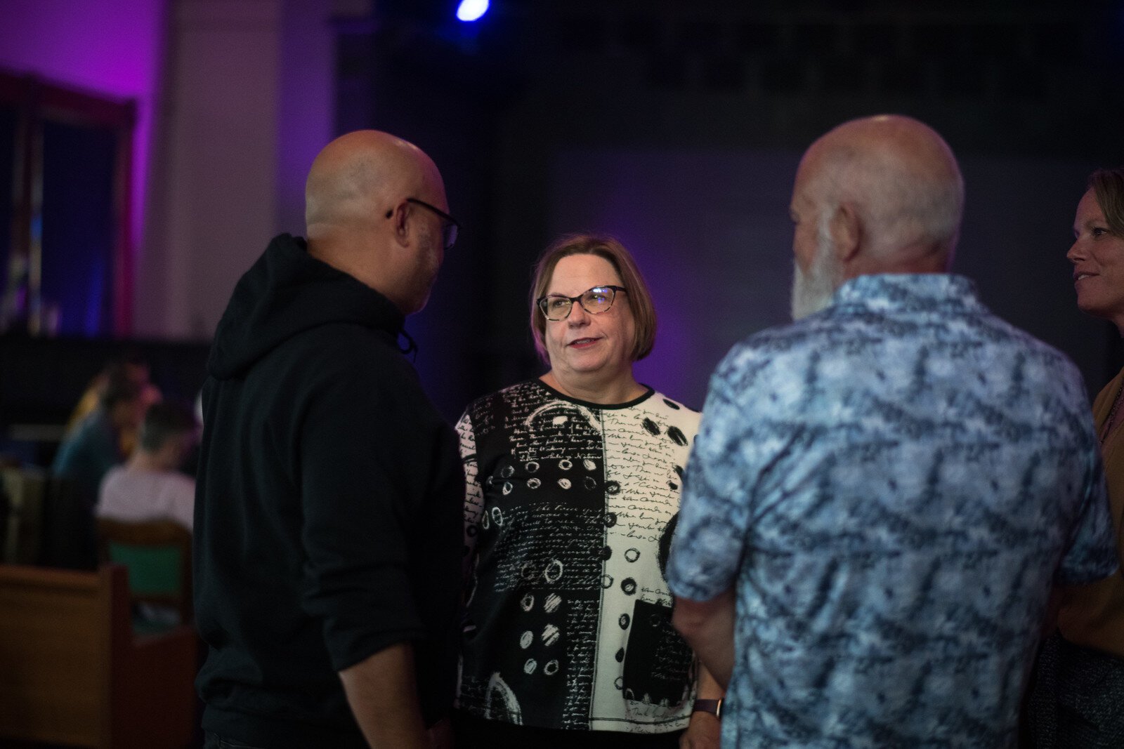 Beth McCann, executive director of Kalamazoo Neighborhood Housing Services, talks with Gabriel Giron of the spoken word duo Kinetic Affect. 