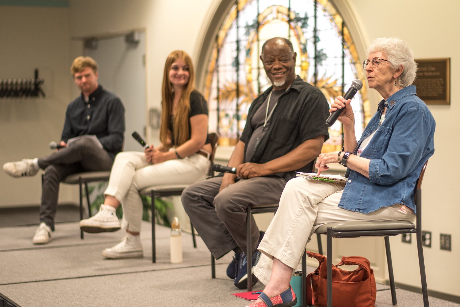 Kalamazoo Lyceum founder Matthew Miller, and panelists Mia Breznau and Ben Brown listen to panelist Sr. Christine Parks thoughts on Hope for the Planet.