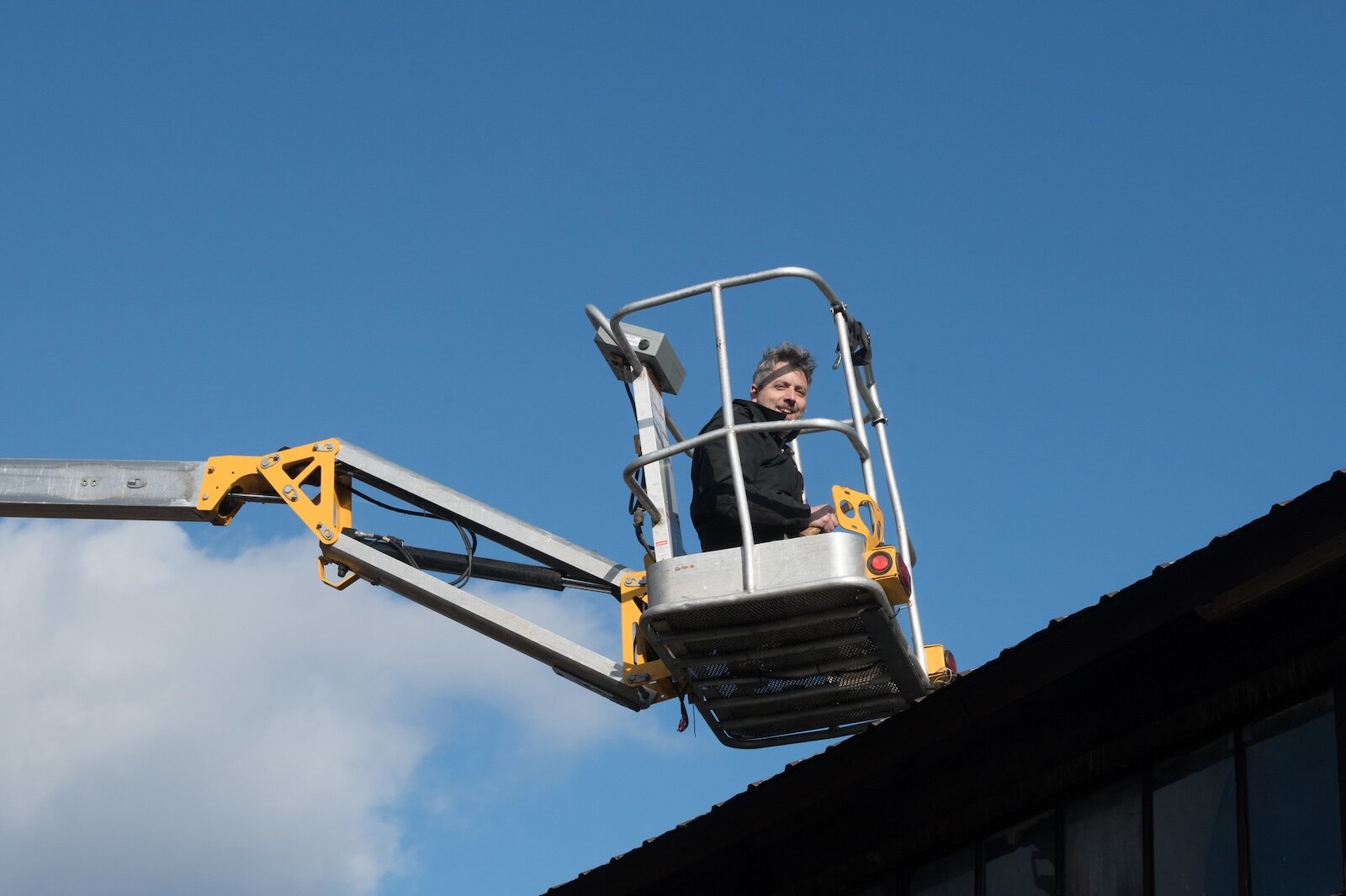 Jeb Gast works on a roof at Jerico last summer. The forklift is sometimes shared among the businesses at Jerico.