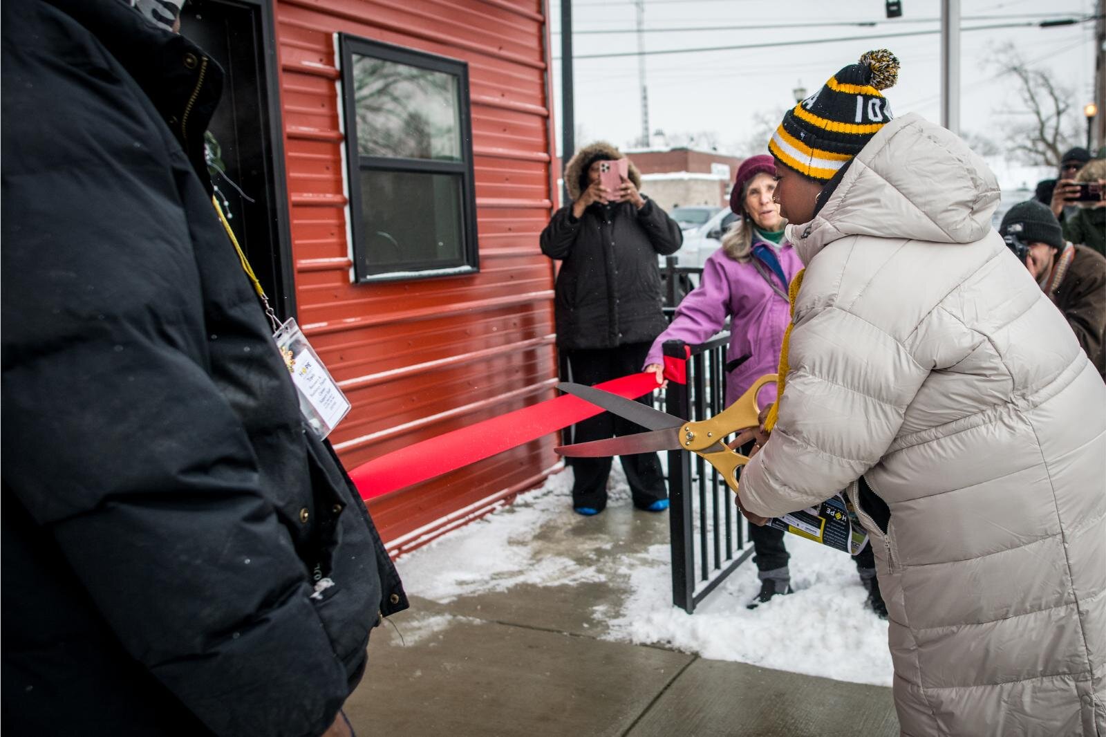 Executive Director Gwen Hooker celebrates the ribbon cutting at the Dec. 12, 2024 open house of the HOPE Thru Navigation tiny houses.