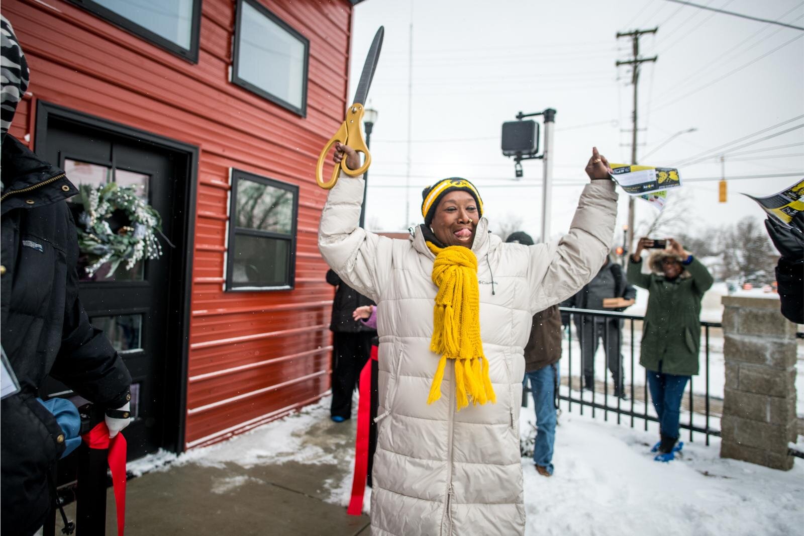 Executive Director Gwen Hooker celebrates the ribbon cutting at the Dec. 12, 2024 open house of the HOPE Thru Navigation tiny houses.