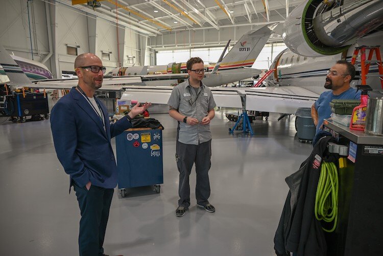  (L-R) Andy Richards, executive vice president and COO of Battle Creek Duncan Aviation, stops to talk with team members David Lidman and Jason Henry inside the new 46,00-square-foot hanger in Battle Creek.