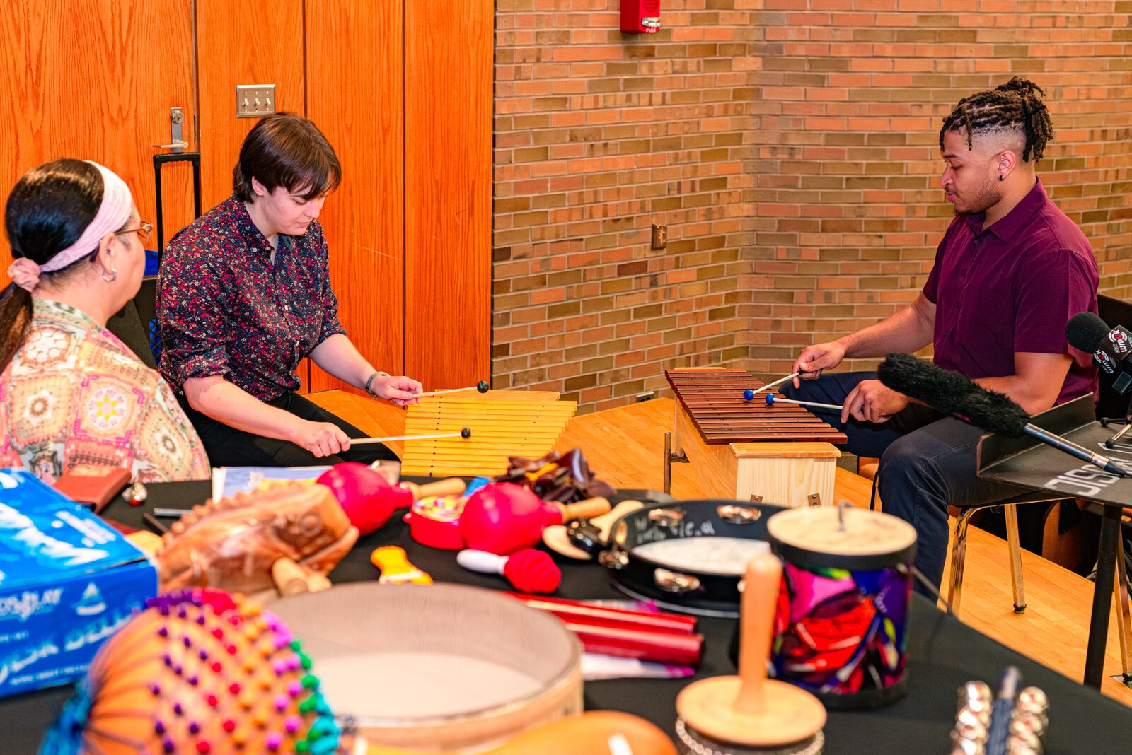 Deanna Bush, instructora en el programa de musicoterapia de la WMU, dirige una actividad de comunicación con Phoebe Ryckbost, y Thomas Valentine, ambos estudiantes de pregrado en el programa de musicoterapia de la WMU tocando el xilófono.