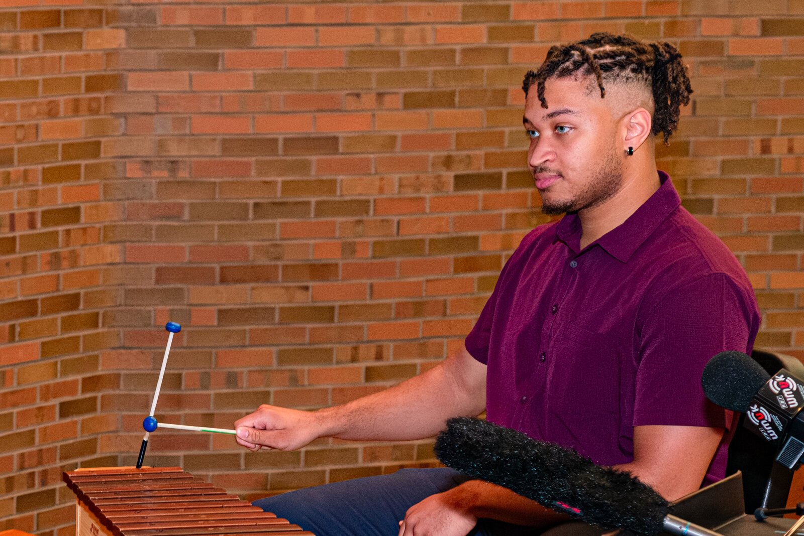 Thomas Valentine, estudiante de pregrado en el programa de musicoterapia WMU demuestra una melodía en un xilófono.