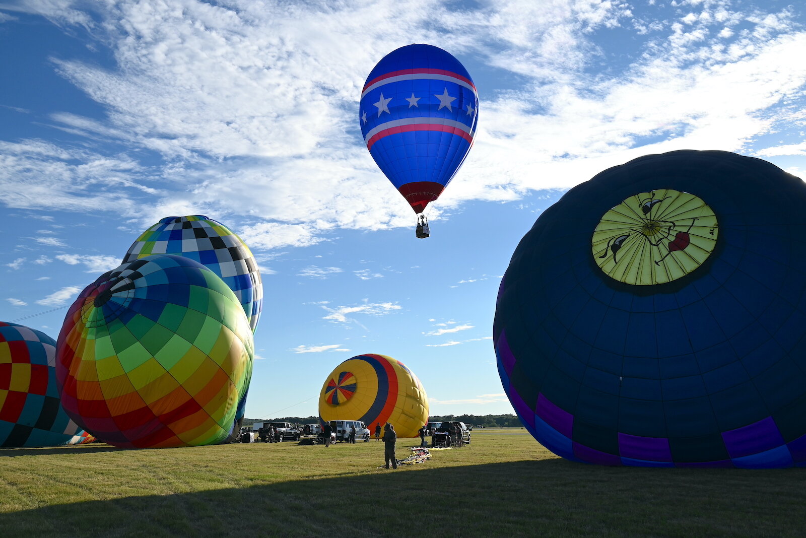 Pilots, their teams, and their balloons prepare and take flight on the evening of July 3.