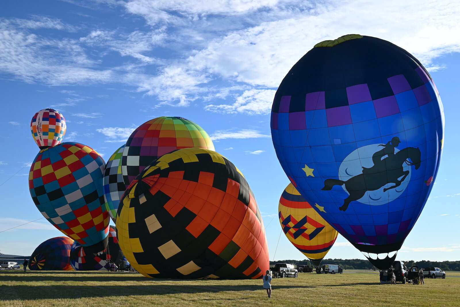 Pilots, their teams, and their balloons prepare and take flight on the evening of July 3.