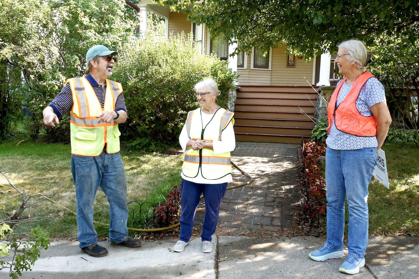 West Main neighbors Rob and Claire Milne (left) and Bess Fitzgerald, all in their safety vests.. 