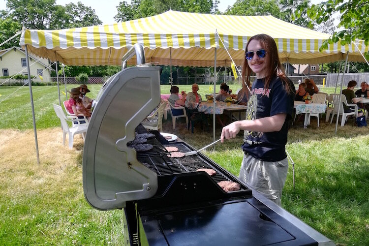 R.J. Lawson helps grill hamburgers and hot dogs at the 2019 Oakwood Neighborhood Reunion.