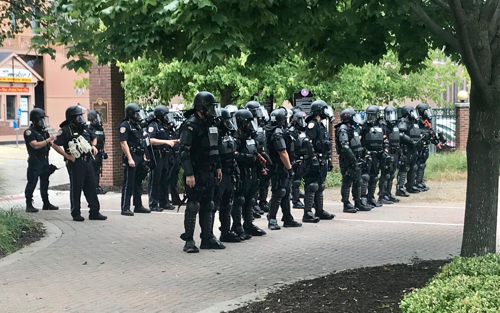 Police in riot gear form a line just inside the east entrance of Arcadia Creek Festival Place. Other officers entered at other points in order to clear the area.