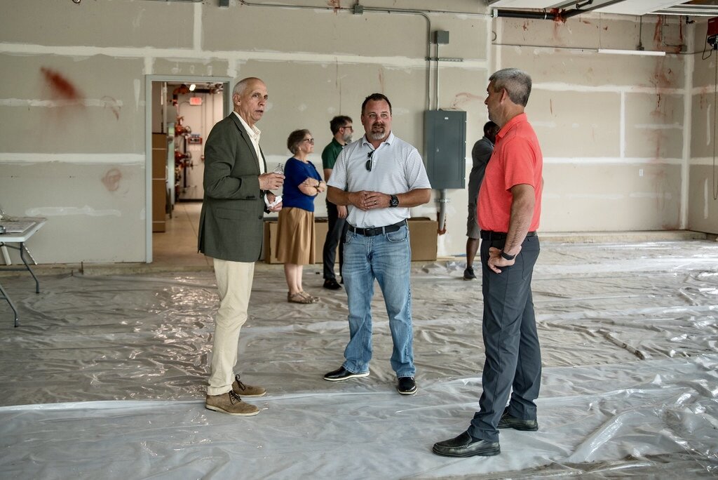 Kalamazoo Mayor David Anderson, left, and Project Manager Ryan Vlietstra center, talk while inside the open commercial space at Eastside Square Condominiums.