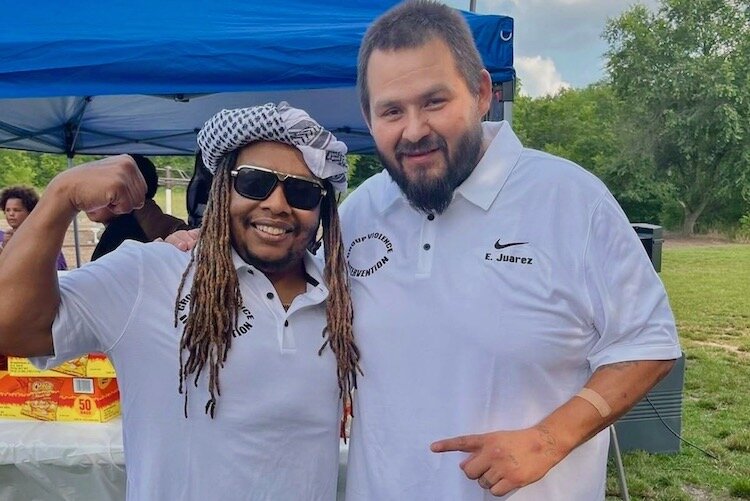 Michael Wilder, left, stands with Esteven Juarez at an August 2024 community gathering. Such events allow GVI outreach workers to talk with young people.