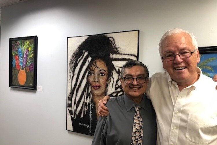 George Martinez, left, and Andrew Freemire, a Battle Creek-based artist, stand together in front of a painting by Martines titled "Selena."