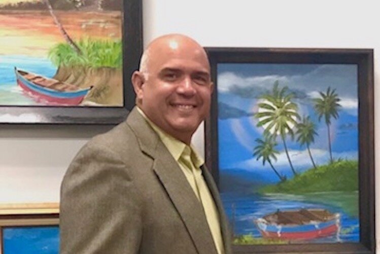 Fausto Fernandez poses in front of some of his paintings which are part of the LAGL exhibit at Commerce Pointe.